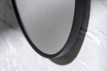Detaljbild oval dekorativ spegel i svart ram av MDF