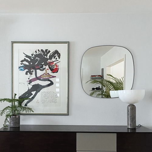 Unik spegel med svart metallram i vardagsrum